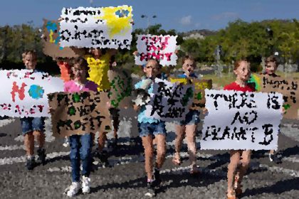Group of people holding protest signs at an outdoor event on a sunny day, marching together.
