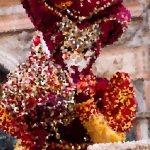 Colorful mosaic sculpture of a bird with red, orange, and yellow tiles.