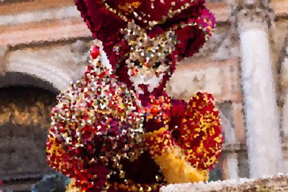Colorful mosaic sculpture of a bird with red, orange, and yellow tiles.