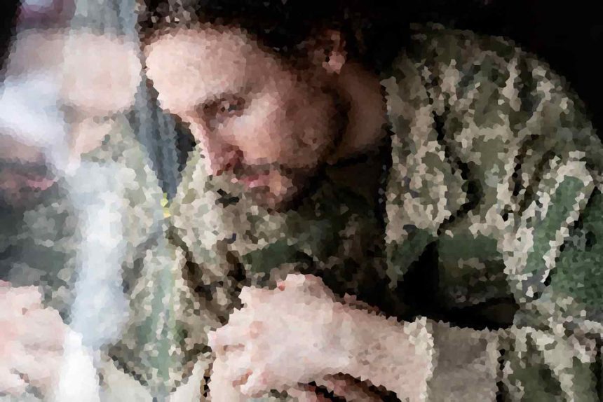 Two people kissing in a dark, outdoor setting, though the image is heavily pixelated and details are unclear.