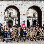 Crowd gathered in front of a white historic building with two large arches and a busy plaza.