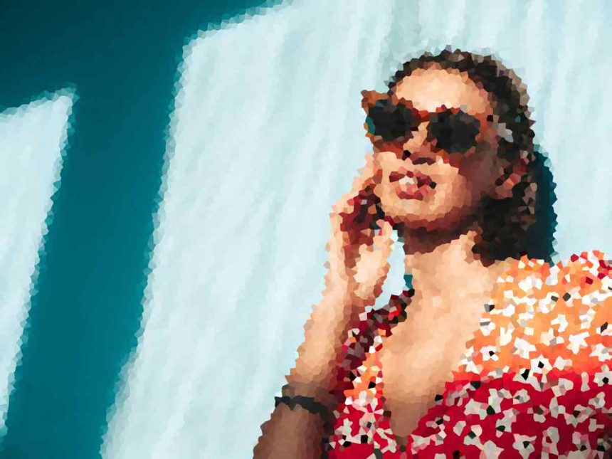 Person wearing a red floral shirt and sunglasses, talking on a cellphone against a blue background.