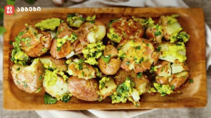 Roasted baby potatoes with chopped parsley and herbs on a wooden serving board.