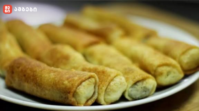 Plate of golden brown fried pastry rolls arranged on a white plate, with a crispy outer crust and pale filling visible at the ends.