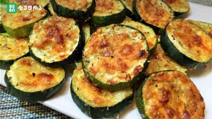 Plate of golden-brown baked zucchini rounds with melted cheese on top on a white dish.] , but remove bracket?