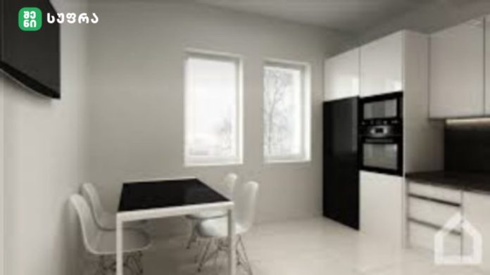 Modern white kitchen with black dining table and four white chairs, built-in oven, and two windows.