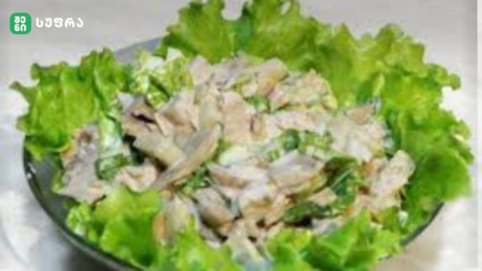 Bowl of chopped chicken salad on a bed of green lettuce.
