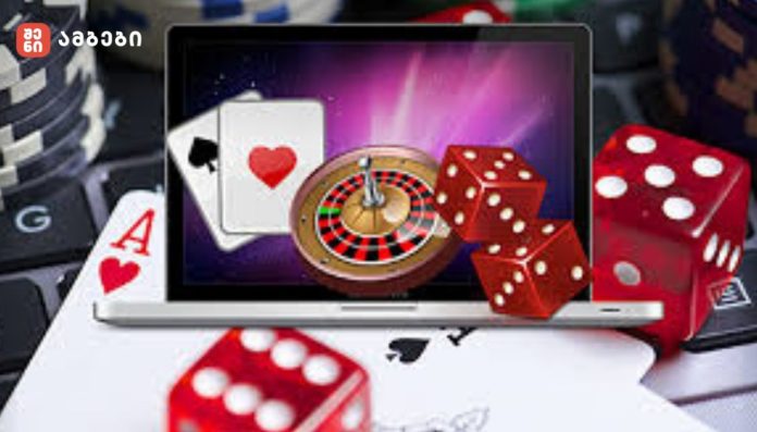 Laptop screen displays a roulette wheel, playing cards, and red dice—symbolizing online gambling.