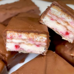 Chocolate-covered wafer candies with white cream and pink strawberry-like filling; a bar is cut in half to reveal the layers.