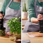 Two people in green shirts and gray aprons using a handheld blender in a bright kitchen; left side herbs and garlic on the counter, right side salmon being prepared with an immersion blender in front of them.