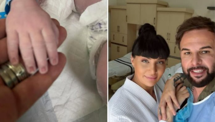 Close-up of a newborn's small hand resting on an adult's finger with a ring visible. Right: a smiling couple in a hospital room posing for a selfie wearing hospital attire.