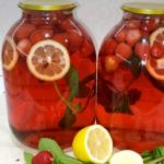 Two large glass jars filled with a red fruit-infused drink with lemon slices and berries, on a white countertop; foreground shows lemons, mint, strawberries, and apples.