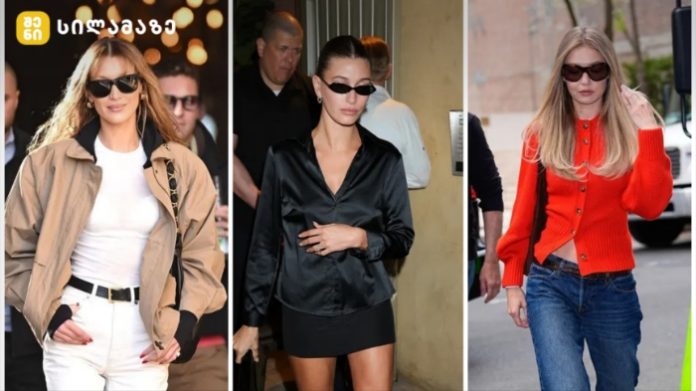 Three women wearing sunglasses in an urban setting: left in beige trench over white outfit, center in black satin blouse with mini skirt, right in red cardigan and jeans.