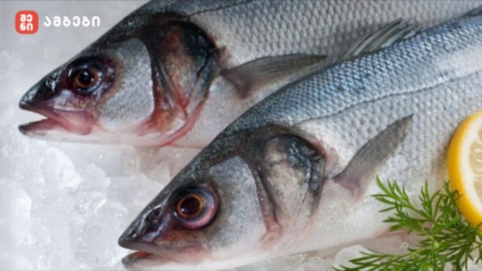 Two raw fish laid on crushed ice with a lemon slice and dill garnish, branding in the top-left corner.