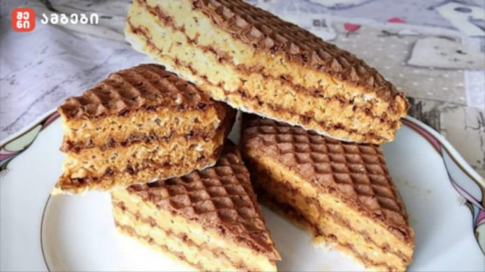 Stack of chocolate wafer cookies on a white plate, with layered filling and a ridged surface.