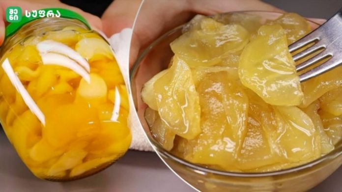 Glass jar filled with sliced yellow peaches in syrup beside a bowl of peach slices on a fork.