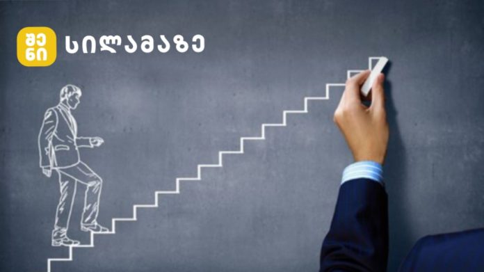 Businessperson climbing a chalk-drawn staircase on a chalkboard, symbolizing progression, with a brand logo in the top-left corner.