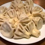Plate of Georgian dumplings (khinkali) arranged in a ring on a white plate