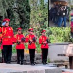 Ceremonial guards in red dress uniforms stand with rifles at a memorial, with greenery in the background and additional collage images surrounding them.