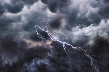 Lightning bolt arcs through dark storm clouds as rain falls across the scene.