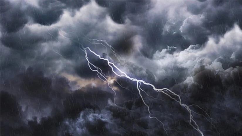 Lightning bolt arcs through dark storm clouds as rain falls across the scene.