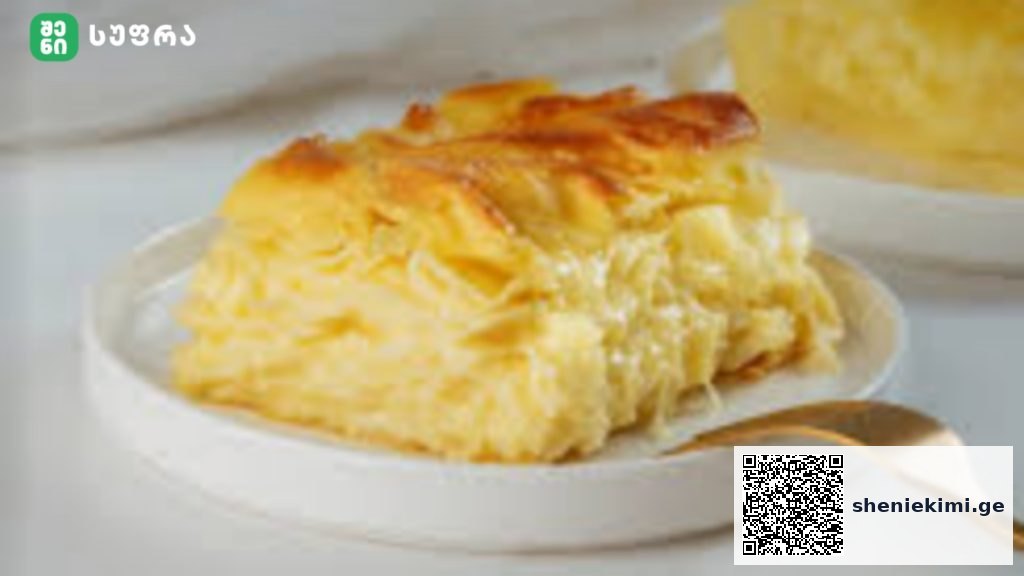 Slice of mille-crepe pastry with creamy layers on a white plate, with a gold spoon nearby.