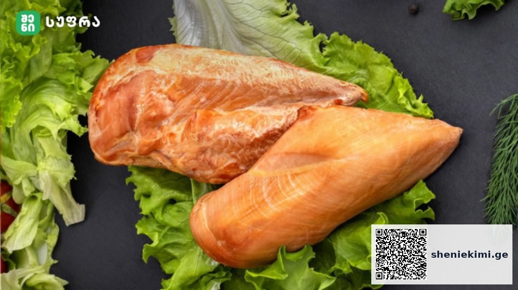 Two raw salmon fillets resting on a bed of lettuce on a dark surface.