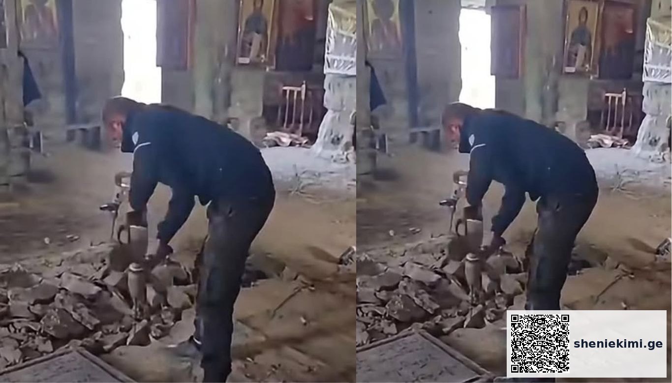 Construction worker in dark clothing chiseling rubble with a hammer inside a partially built brick room.