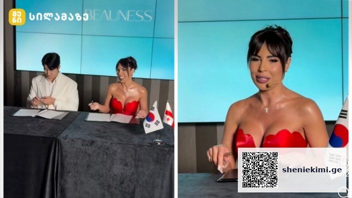 In-studio TV scene: a man and a woman sign papers at a desk with flags, shown in a split view with the woman in a red dress on the right.