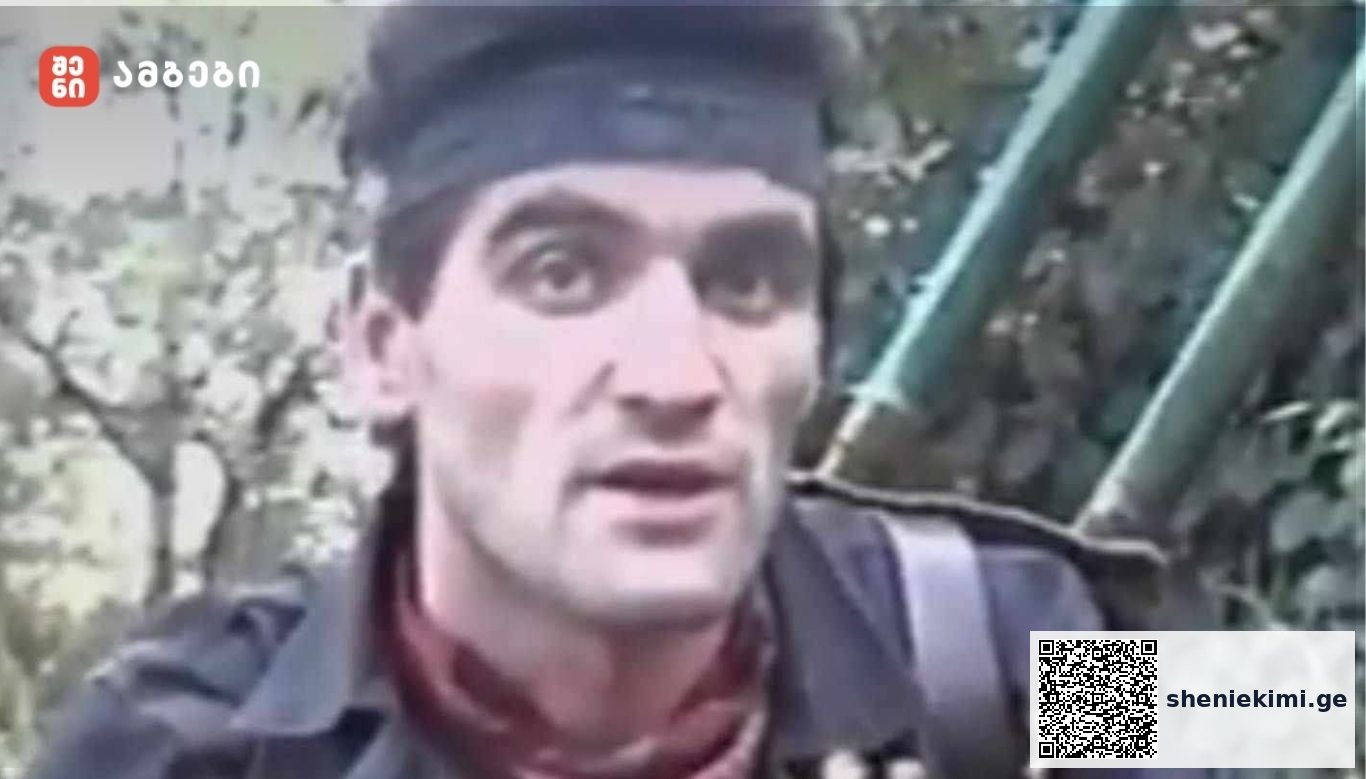 Man wearing a dark headband and jacket outdoors near a green metal staircase.