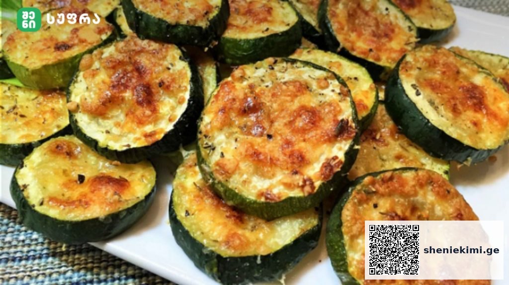 Plate of golden-brown baked zucchini rounds with melted cheese on top on a white dish.] , but remove bracket?