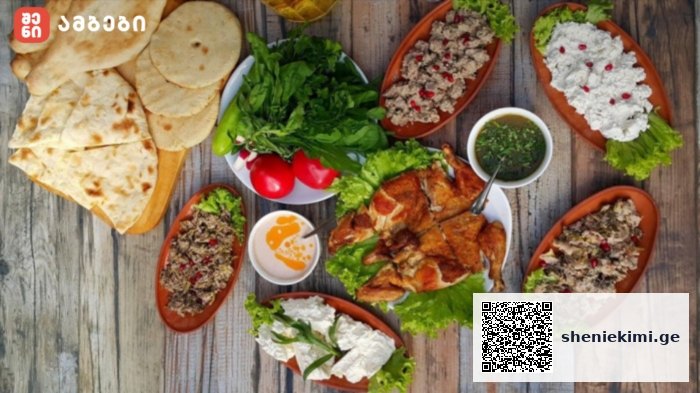 Assorted Middle Eastern dishes on a wooden table: pita bread, fresh greens and tomatoes, hummus, and grilled chicken kebabs with dips.