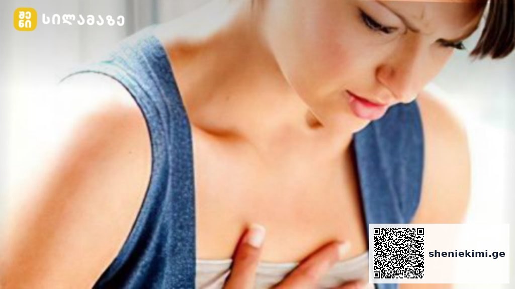 Woman performing a breast self-exam, pressing her chest with fingers