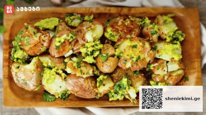 Roasted baby potatoes with chopped parsley and herbs on a wooden serving board.