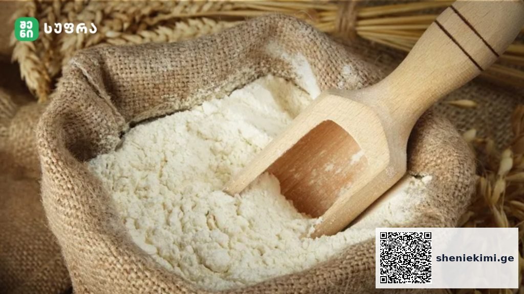 Burlap sack of flour with a wooden scoop resting inside the flour.