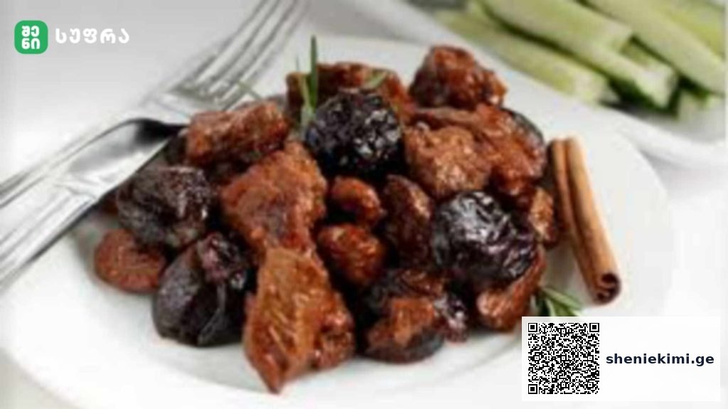Plate of fried meat chunks mixed with dark prunes, garnished with a rosemary sprig and a cinnamon stick on the side.