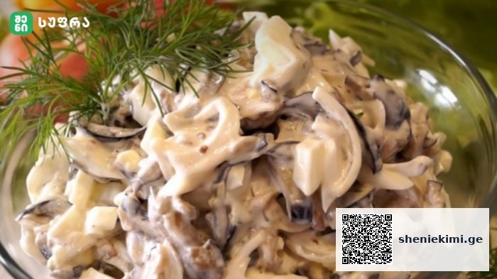 Creamy mushroom and cheese pasta salad in a clear glass bowl, topped with a dill sprig.