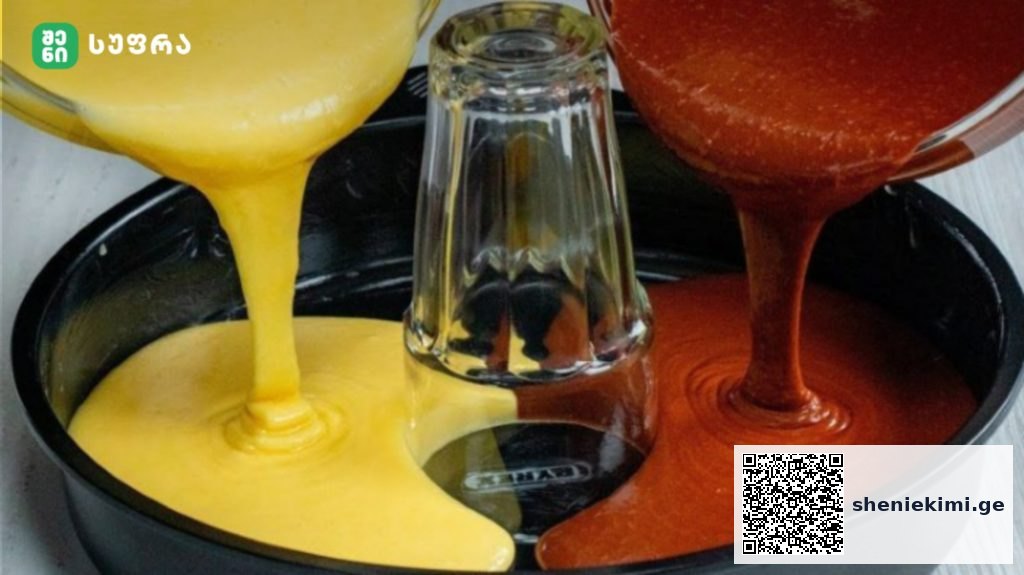 Colorful paint being poured into a round mold from left yellow and right orange-red streams meeting near a glass bottle in the center.