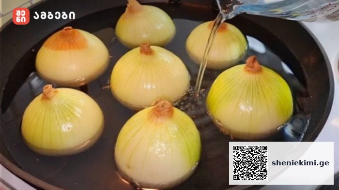 Onions boiling in a pot of water on a stove, their yellowish skins visible above the liquid level.
