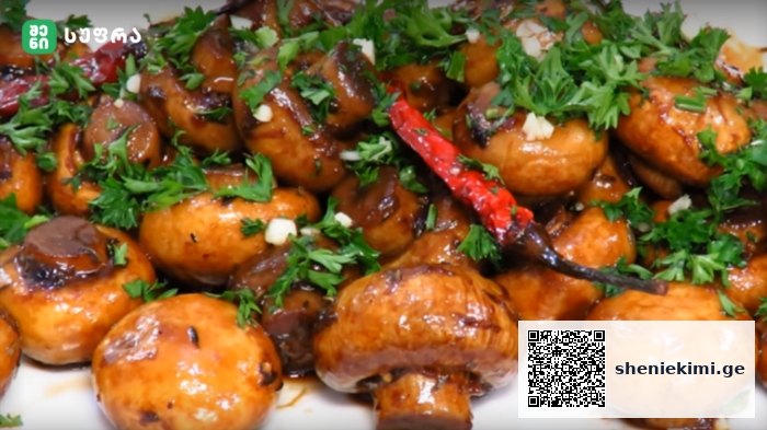Shiny glazed roasted baby potatoes garnished with chopped parsley and a red chili pepper in a brown sauce.
