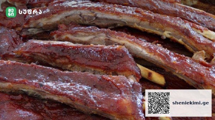 Close-up of glossy, barbecued pork ribs stacked on top of each other.