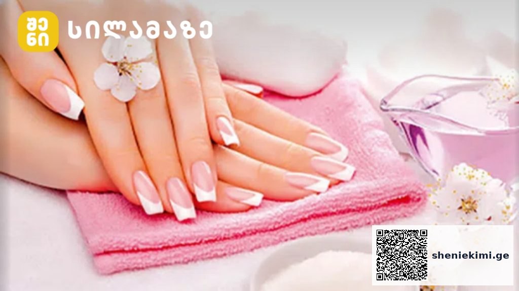 Hands with a pink French manicure resting on a folded pink towel at a spa