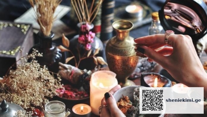 Hands arranging dried herbs on a candlelit altar with vases and bowls nearby, creating a ritual scene.