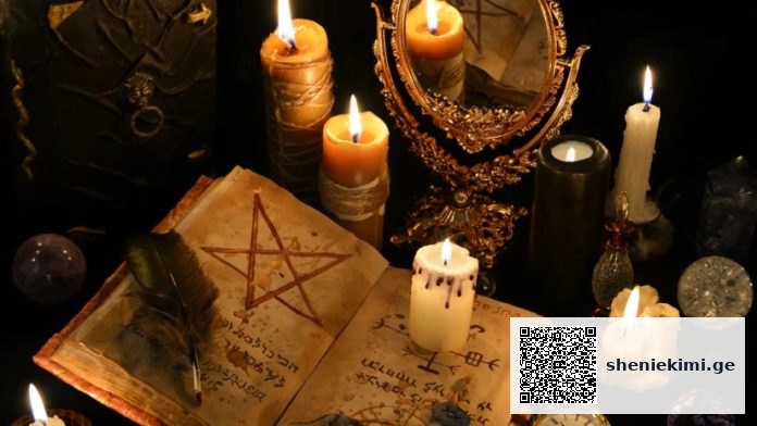 Open spellbook with a pentagram drawn inside, a feather quill, and several lit candles on a dark ceremonial altar with a decorative mirror and crystals nearby.