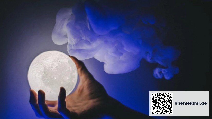 Hand cradling a glowing full-moon orb against a dark blue smoky background.