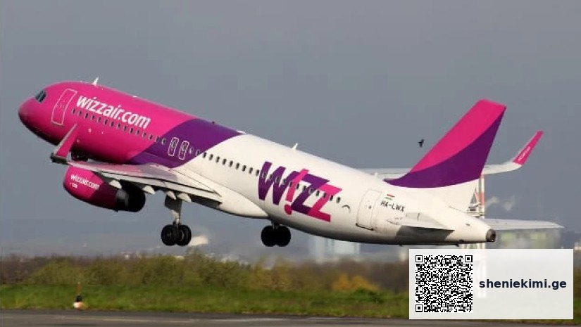 Wizz Air jet taking off from the runway with pink and purple livery in ascent.