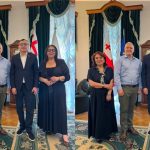 ბათუმის შოთა რუსთაველის სახელმწიფო უნივერსიტეტსა და Georgian Medical Journal-ს შორის სტრატეგიული თანამშრომლობის პერსპექტივები განიხილეს Four adults posing for a formal group photo in a room with draped curtains and flags behind them (Georgia and EU flags); two women in dark dresses and two men in smart attire stand side by side.