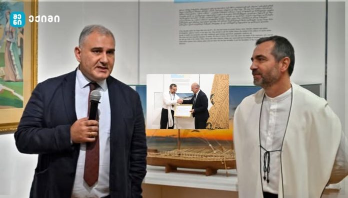 Man in a suit holding a microphone speaks beside a man in a white robe; an inset shows a handshake and certificate.